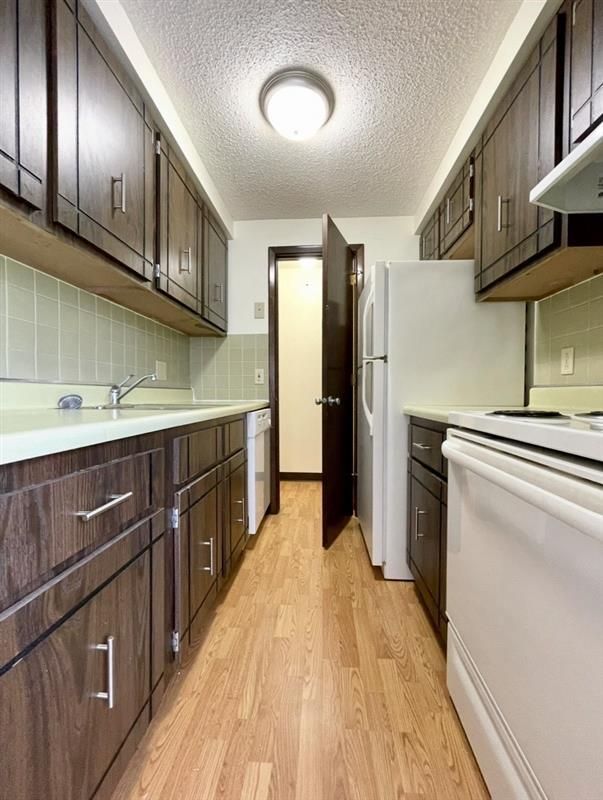 A kitchen with wooden cabinets and a white refrigerator