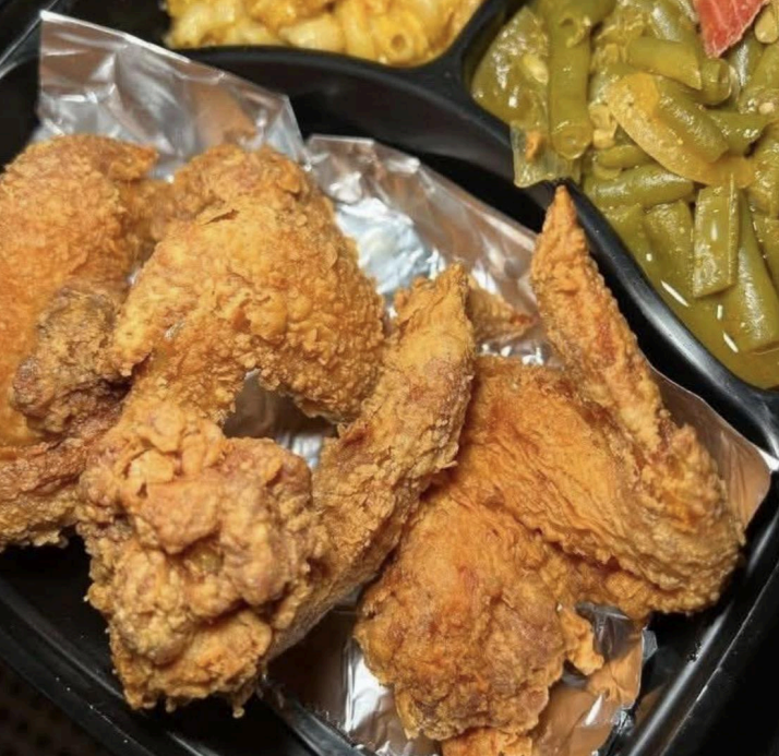 Tray of crispy fried chicken pieces with green beans and macaroni on the side