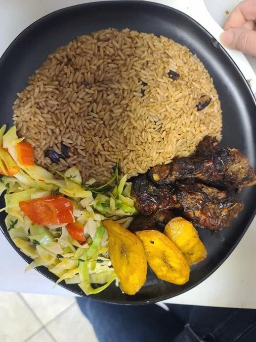 Plate with rice, grilled meat, fried plantains, and a small side salad