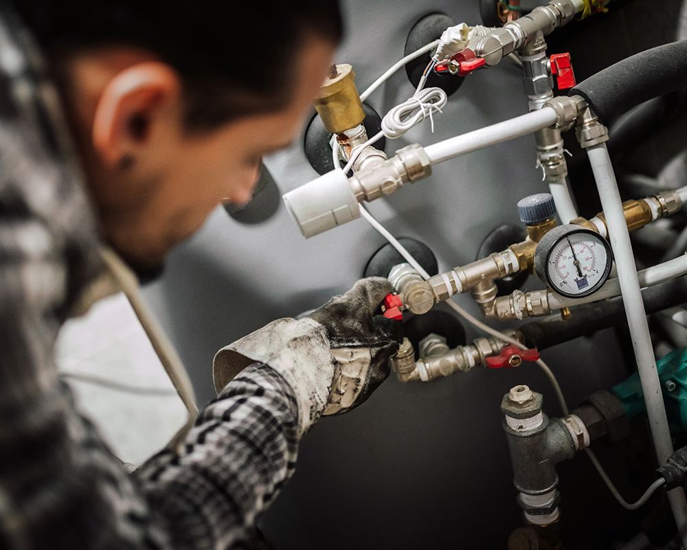 Worker Repairing Pipe System — Millbrook, AL — Headley Plumbing Company