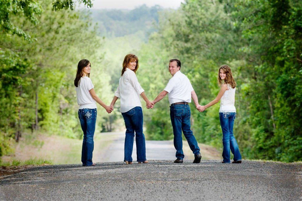 a family holding hands on the side of a road