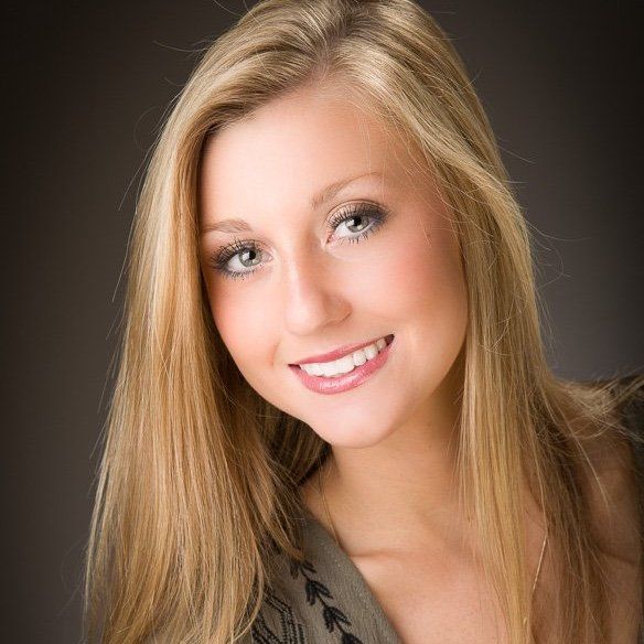 a woman with long blonde hair is smiling for the camera .