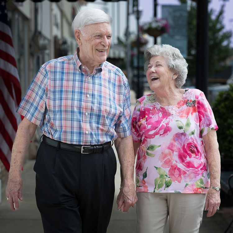 a couple walking down a sidewalk holding hands