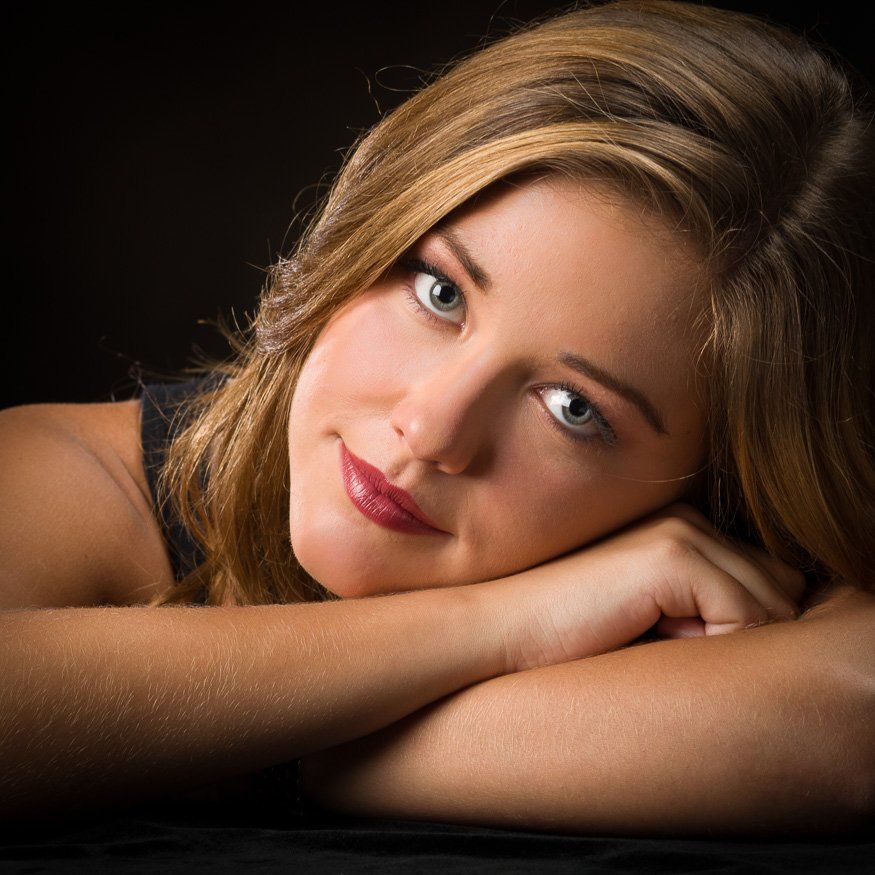 a close up of a woman 's face with her head resting on her hand