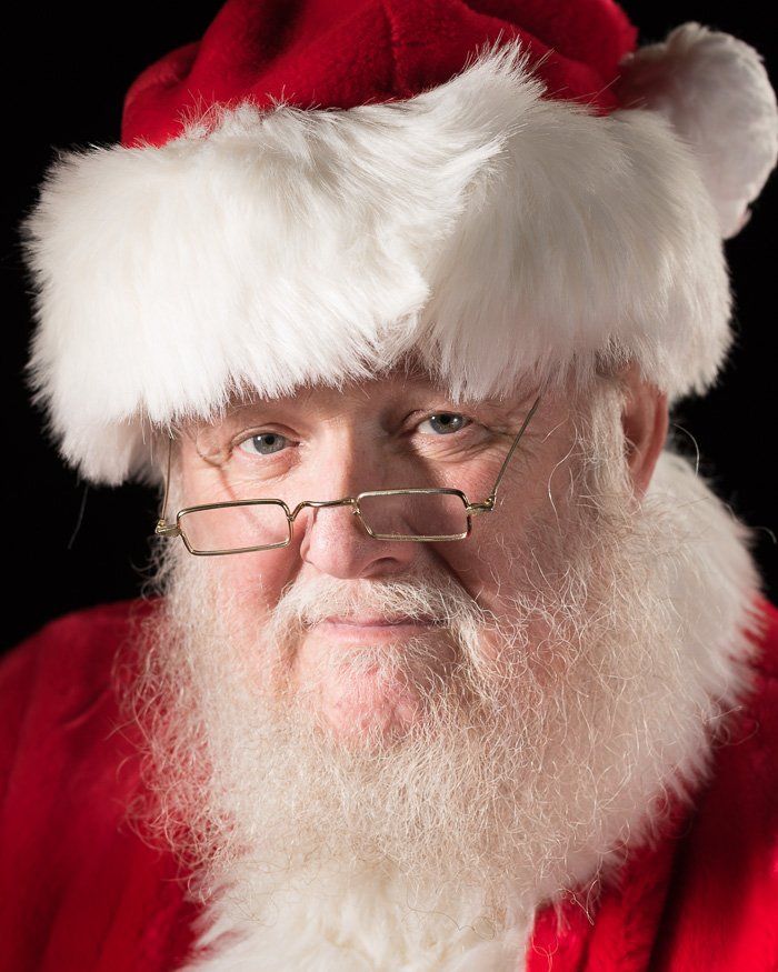 a man with a beard wearing glasses and a santa hat