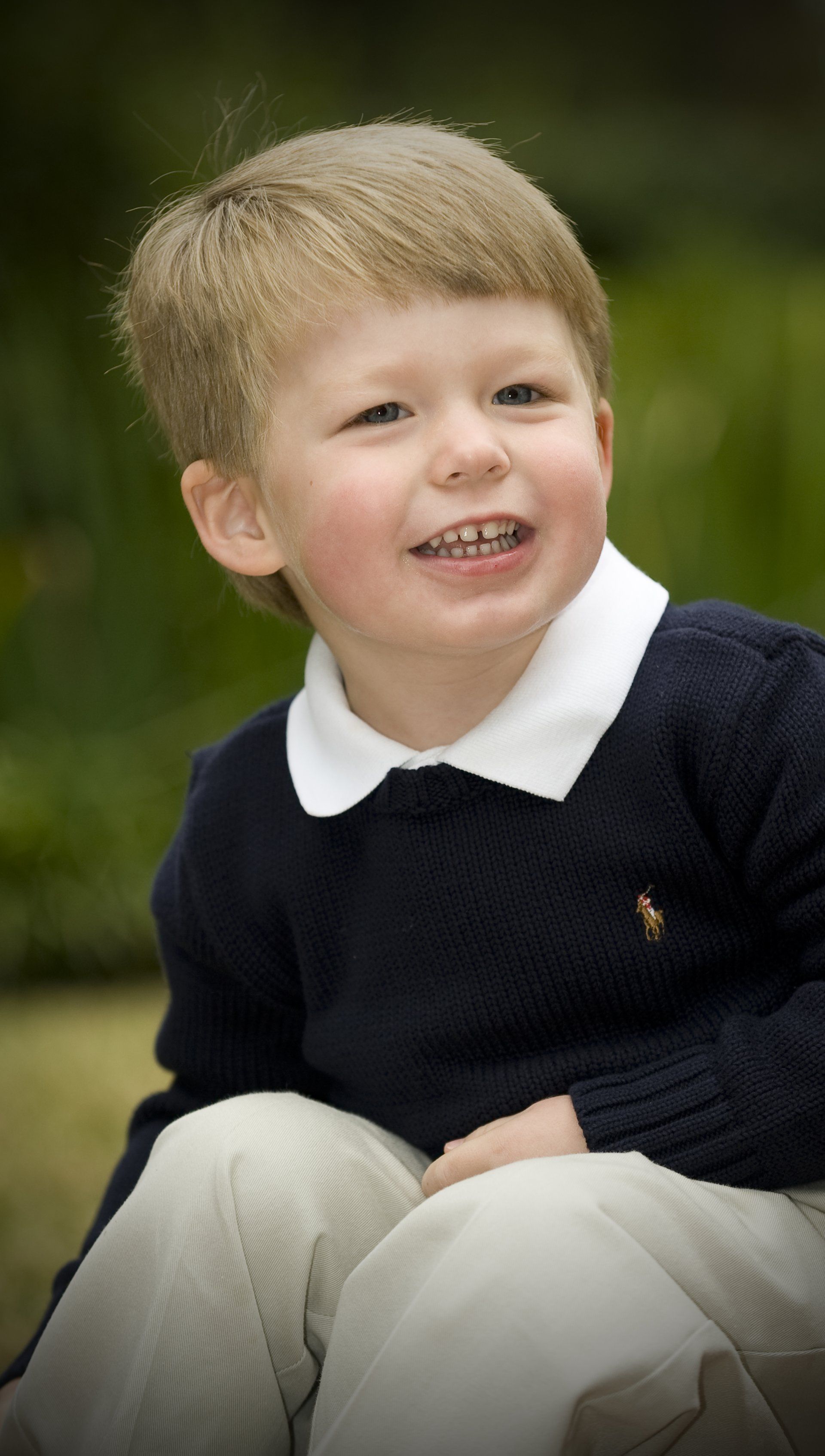 A young boy wearing a polo shirt is smiling