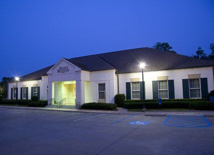a large white building with green shutters is lit up at night .