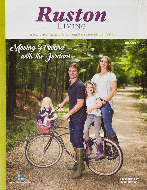 A family is riding a bike on the cover of a ruston living magazine.
