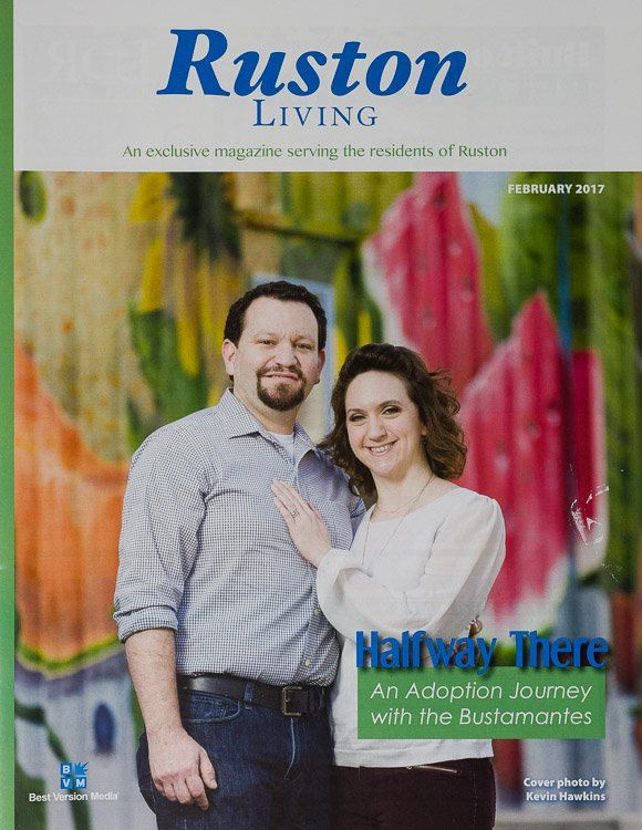 A man and a woman are standing next to each other on the cover of a ruston living magazine.