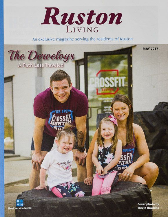 A family is sitting on a tire on the cover of a ruston living magazine.