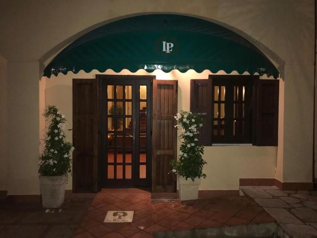 Ampia villa color crema con balconi ad arco, incorniciata da alberi sotto un cielo azzurro.