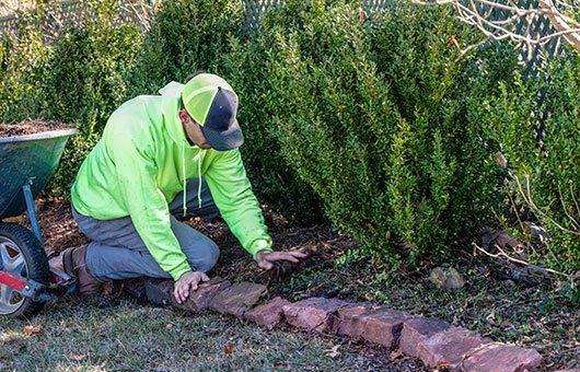 Man Doing Mulching — Nashua, NH — Lone Wolf Landscaping, LLC