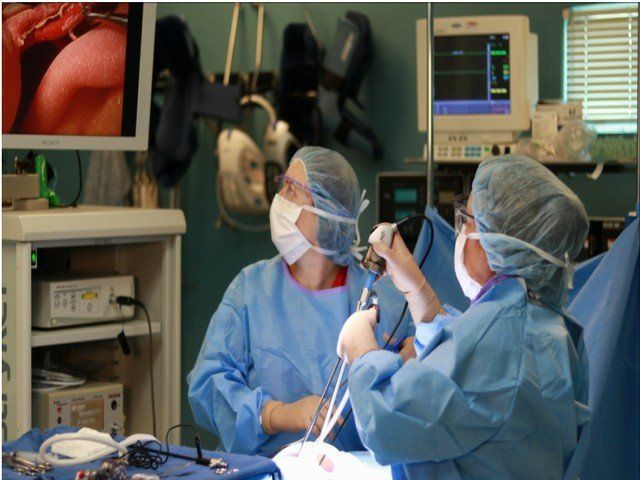 Two surgeons are operating on a patient in an operating room