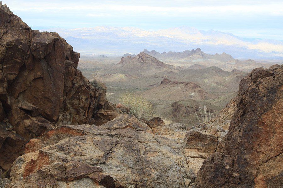A desert landscape with rocks and mountains in the background