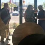 A group of people are standing in front of a window in a room.