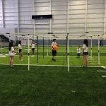 A group of people are playing volleyball in a gym.