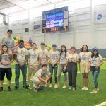 A group of people are posing for a picture on a field.