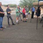 A group of people are standing in a parking lot.