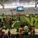 A group of people are sitting on the sidelines of a football field.