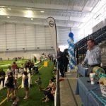 A group of people are standing in a large indoor stadium.