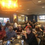 A large group of people are sitting at tables in a restaurant.