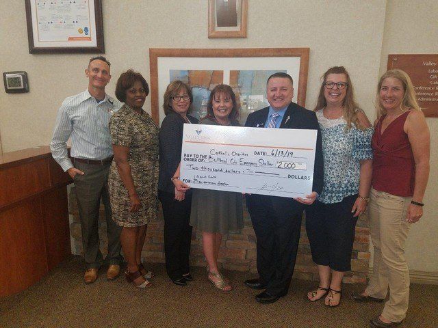 A group of people holding a large check that says $ 250