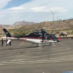 A helicopter is parked on the tarmac at an airport.