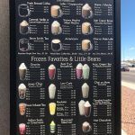 A blackboard with a variety of drinks on it.