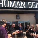 A group of people are standing in front of a human bean store.