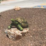 A statue of a turtle sitting on top of a rock.