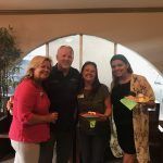 A group of people are posing for a picture in front of a window.