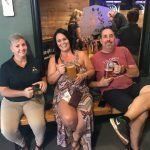 A group of people are sitting on a bench in a restaurant.