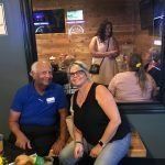 A man and a woman are sitting at a table in a restaurant.