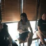 A group of people are sitting in front of a window in a room.