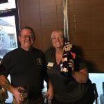 A man and a woman are posing for a picture in a restaurant.