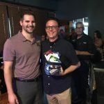 Two men are posing for a picture together in a room.