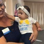 A woman is holding a baby in her arms.