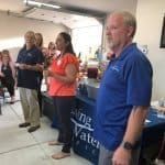 A group of people are standing around a table in a room.