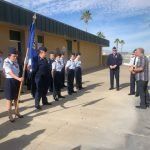 A group of people are standing in front of a building holding flags.