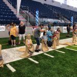 A group of people are standing on top of a football field.