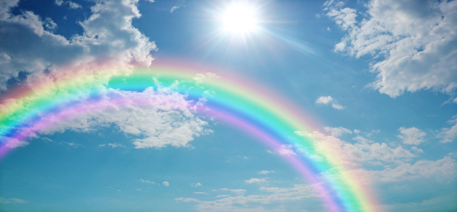 Rainbow across sunny sky