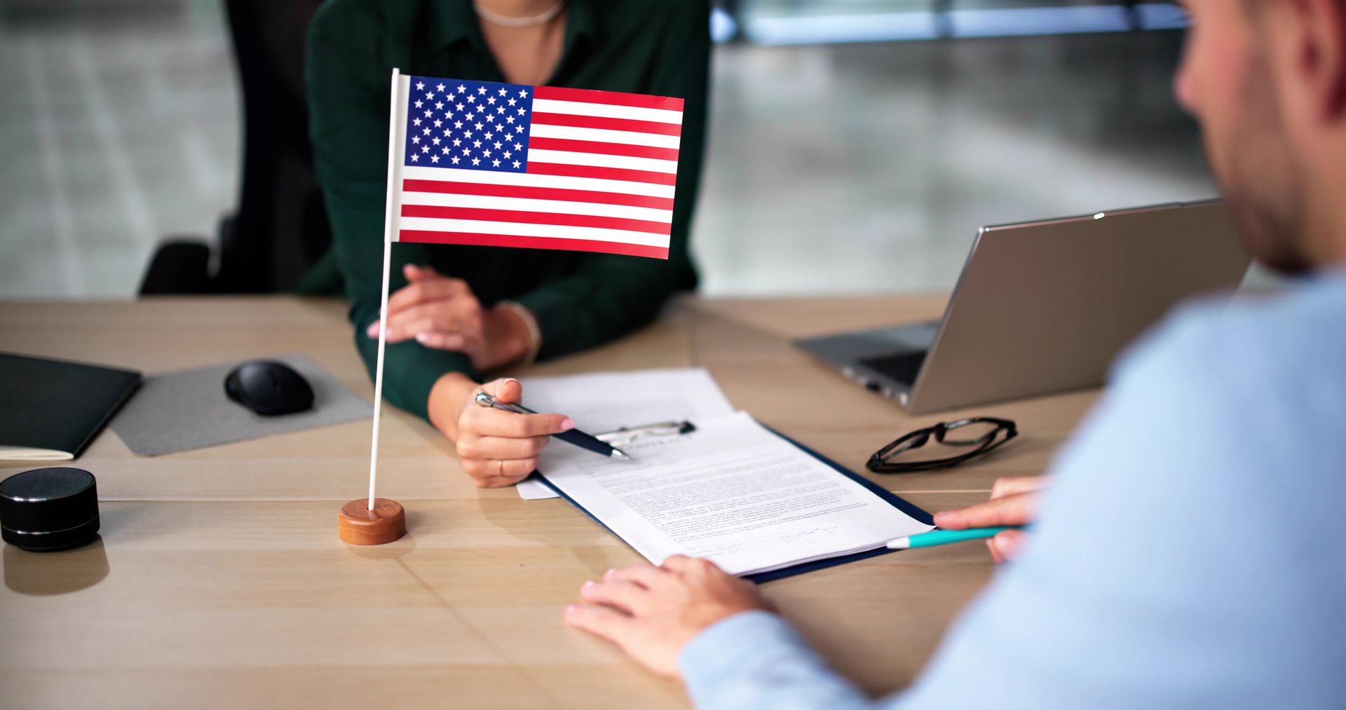 A man and a woman are sitting at a table with an american flag.