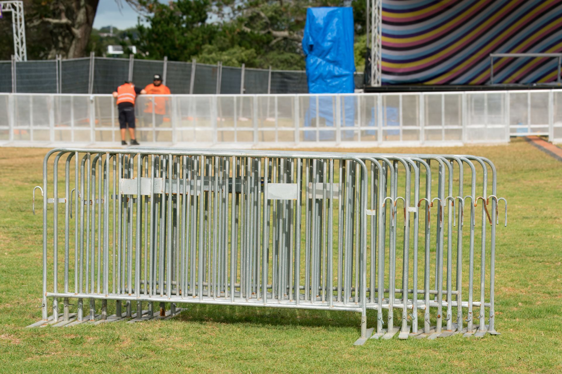 Event barriers on lawn in front of stage under construction.