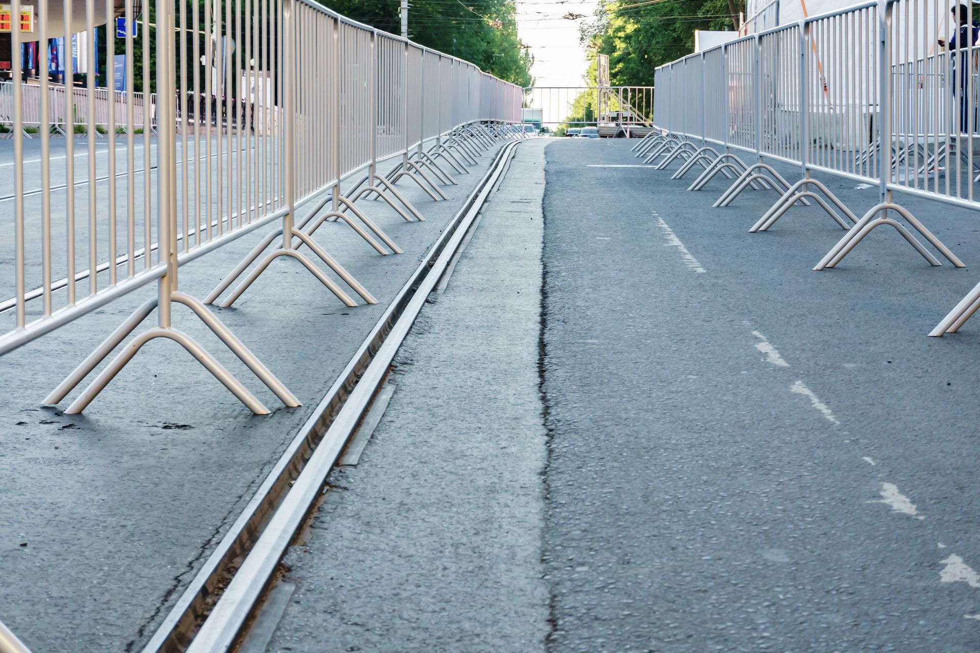 Temporary metal barricades lining a closed roadway to guide pedestrian flow and control access.