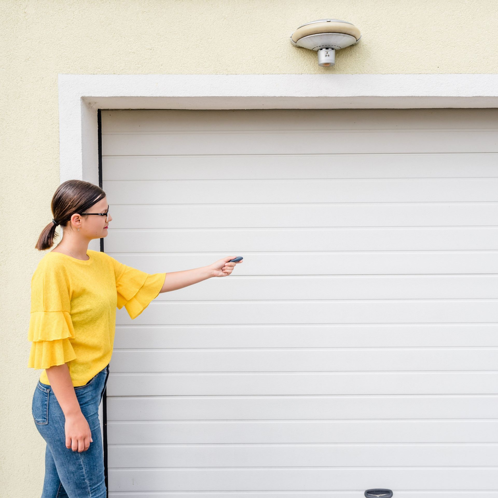 an image of a person using a remote control to open or close a garage door
