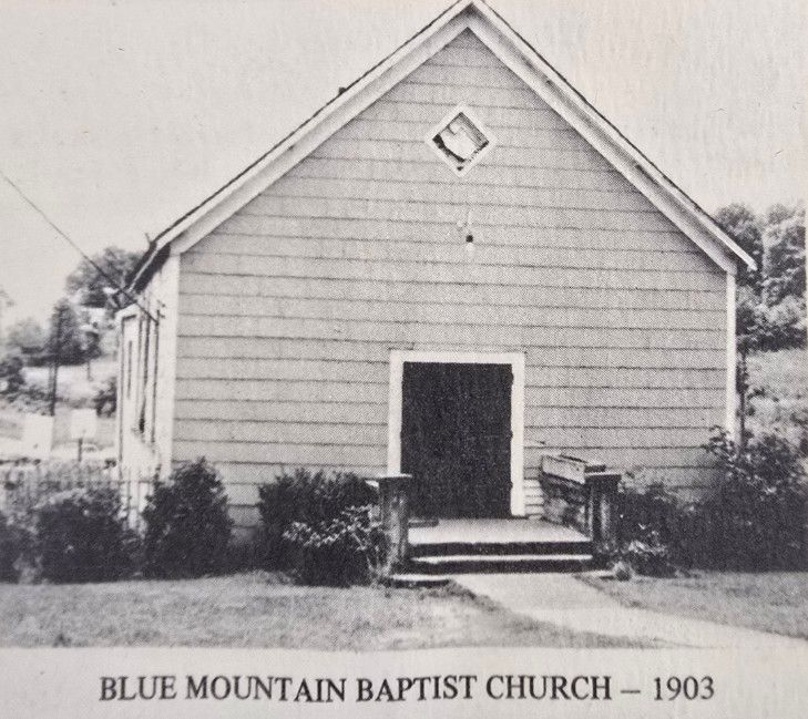 Blue Mountain Baptist Church in 1903. Exterior view of a small, wooden church with a peaked roof and diamond-shaped window.