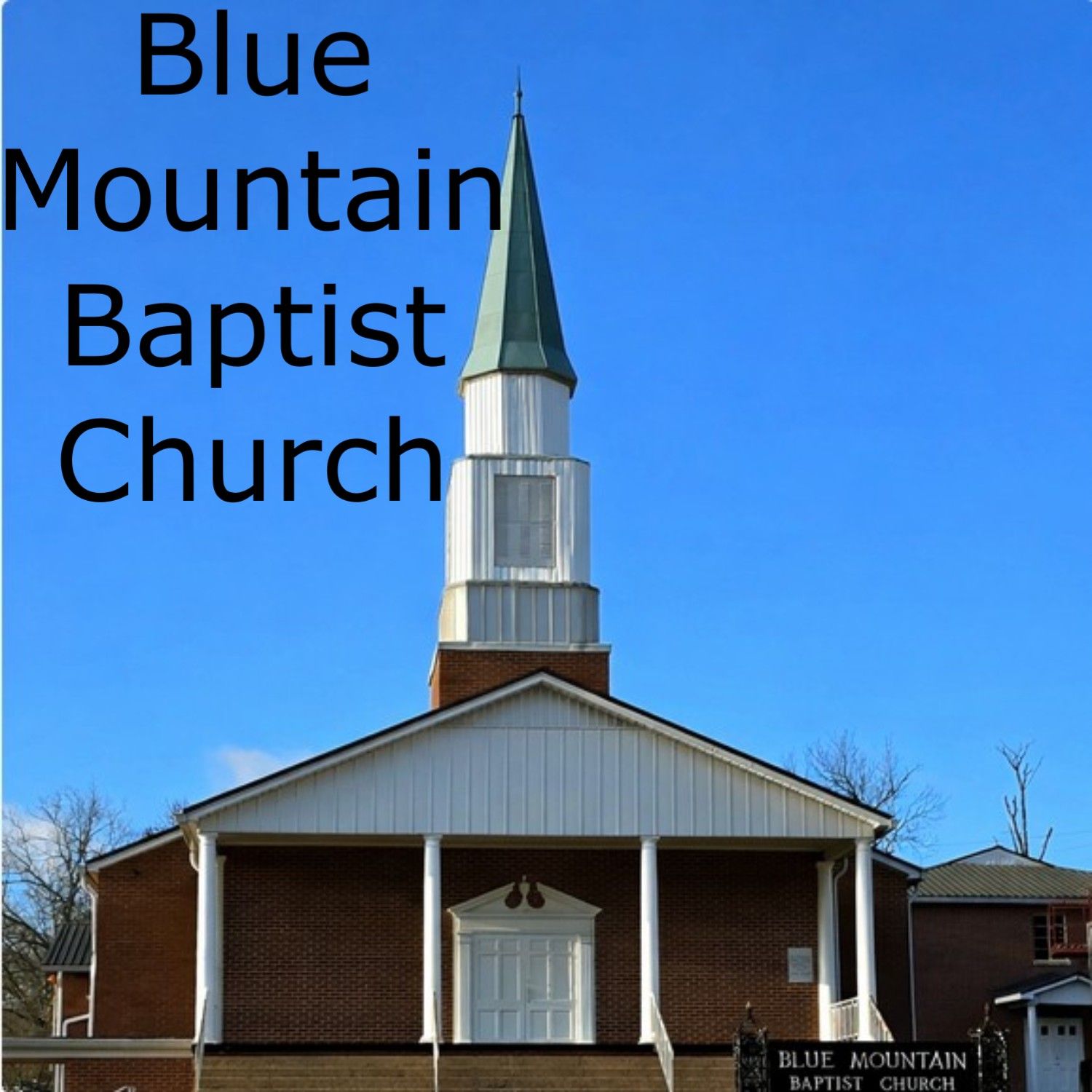 Blue Mountain Baptist Church exterior with steeple and blue sky.