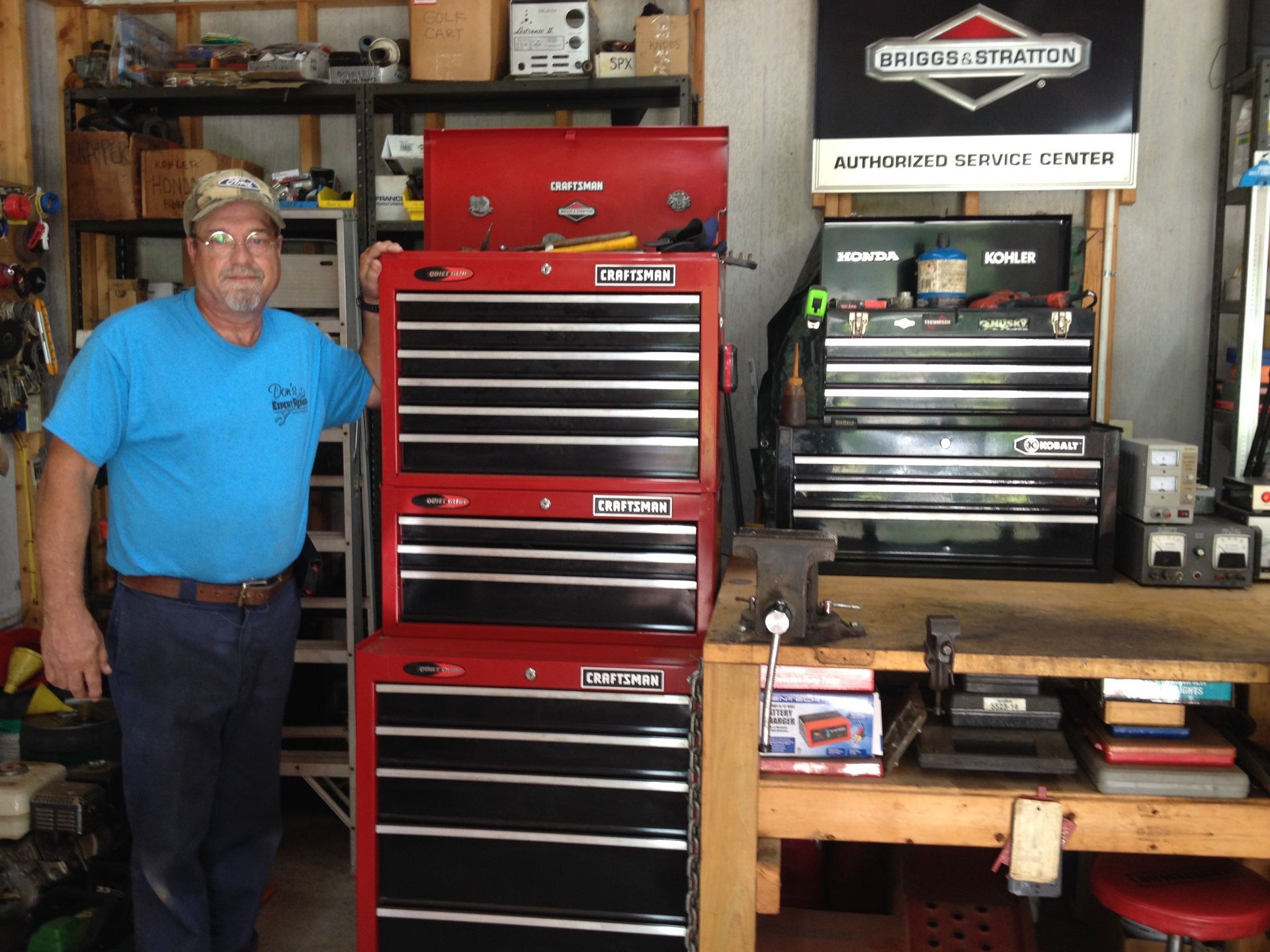 A man in a green shirt is driving a machine in a grassy field.