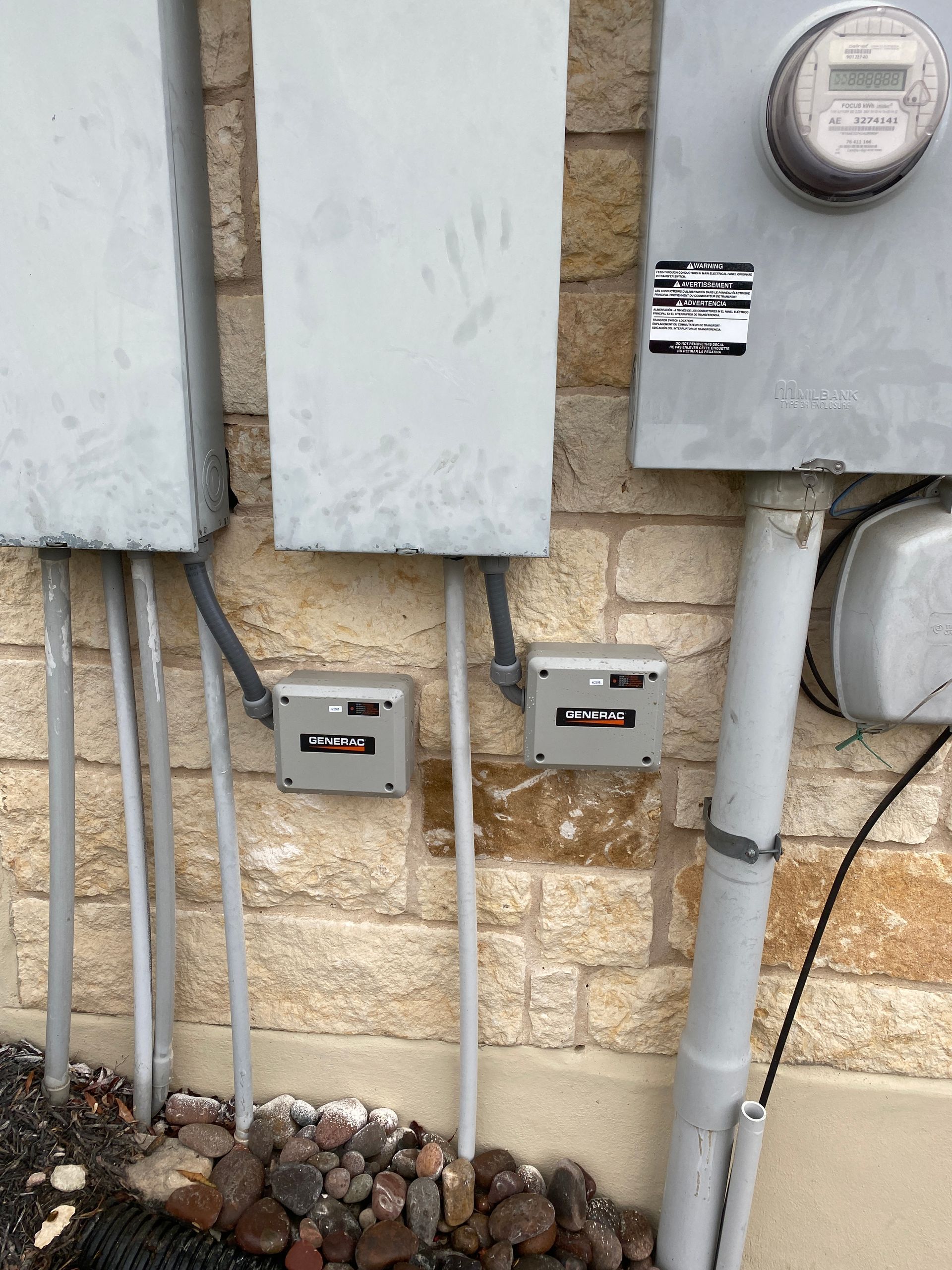 A brick wall with electrical boxes and a meter on it
