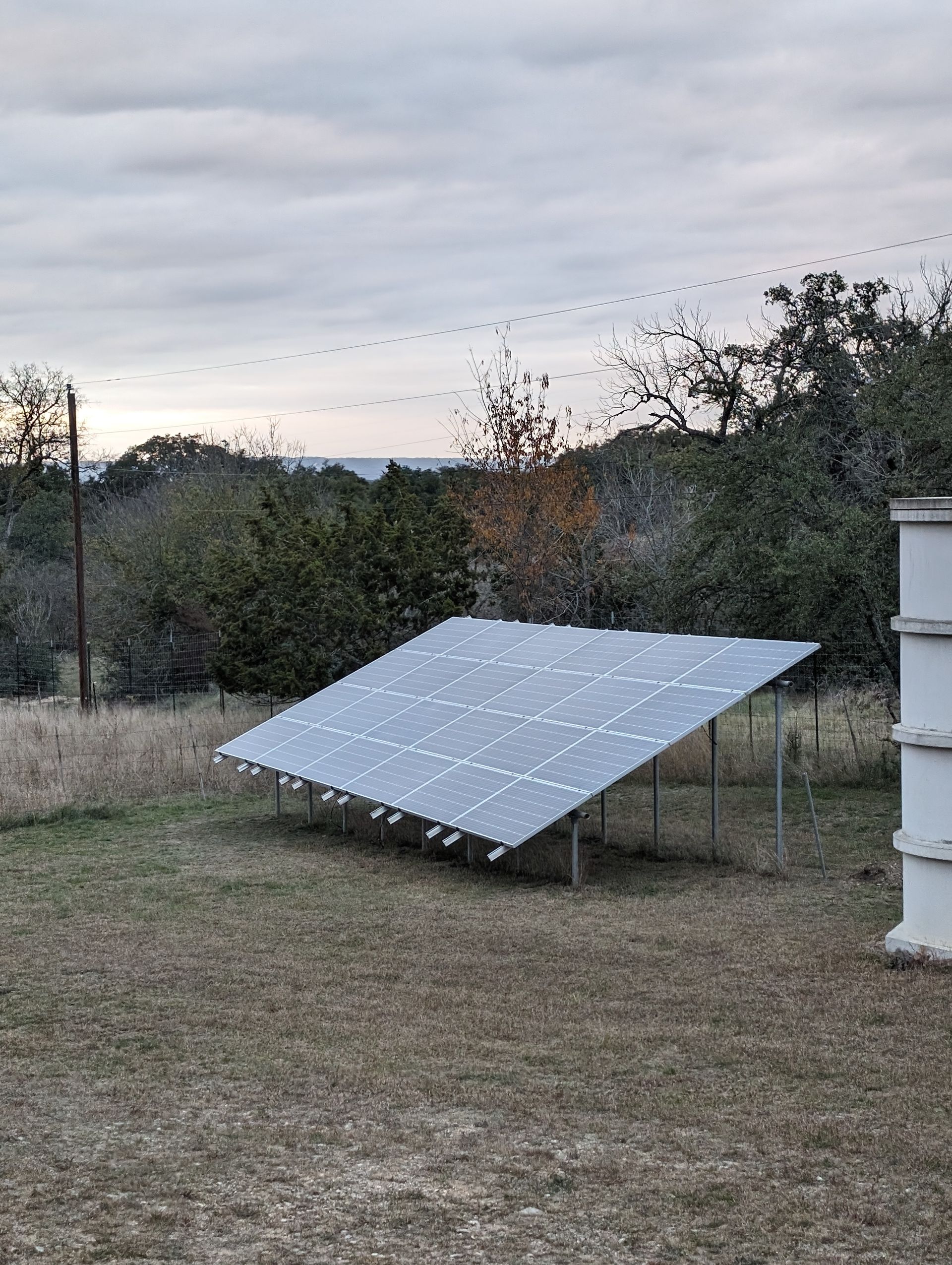 A solar panel is sitting in the middle of a field.